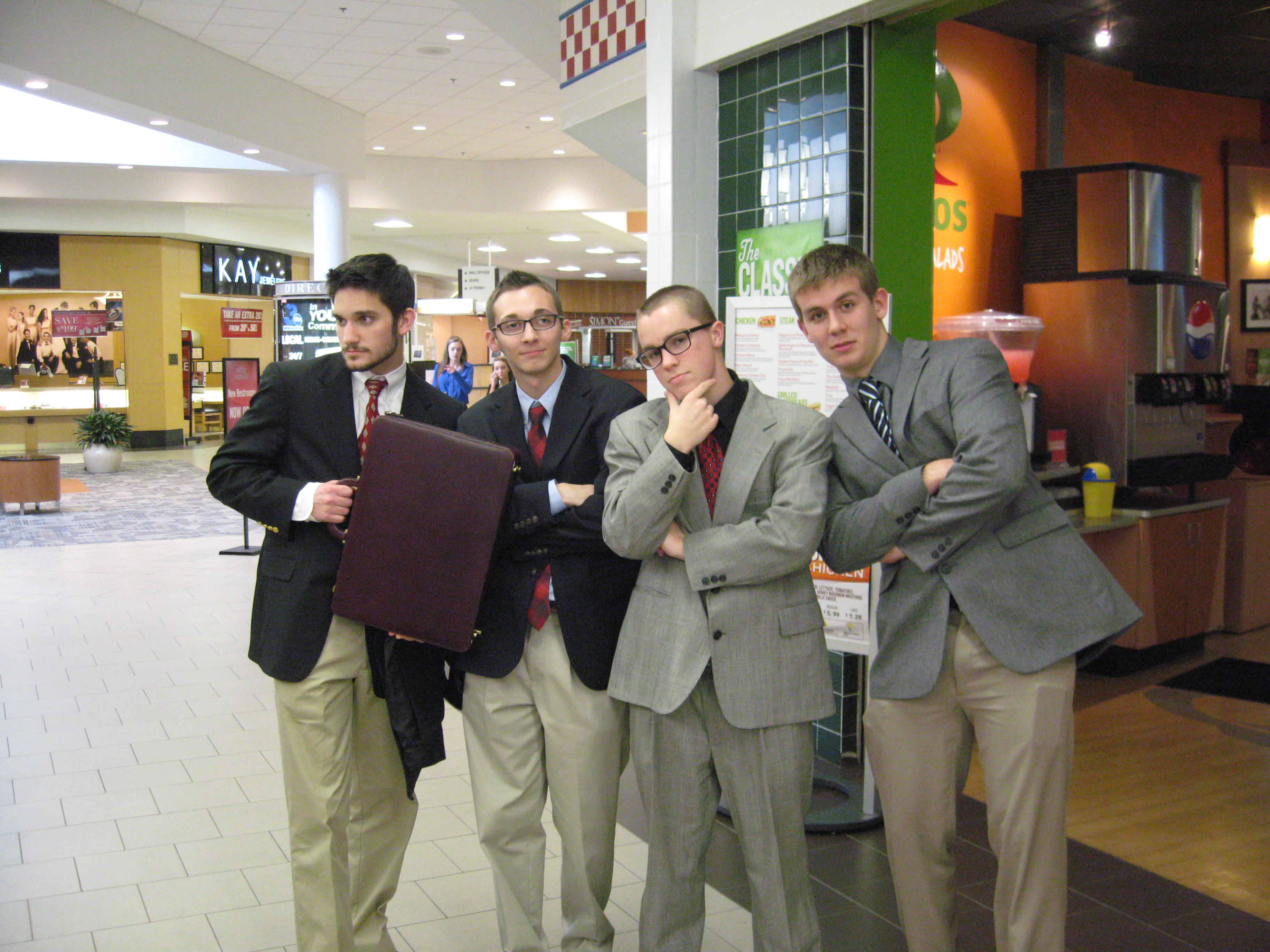 Seniors Colin Steves, Kevin Sanford, Casey Adamowicz and junior Brady Burr pose and prepare for DECA’s regional competition at the Apple Blossom Mall.