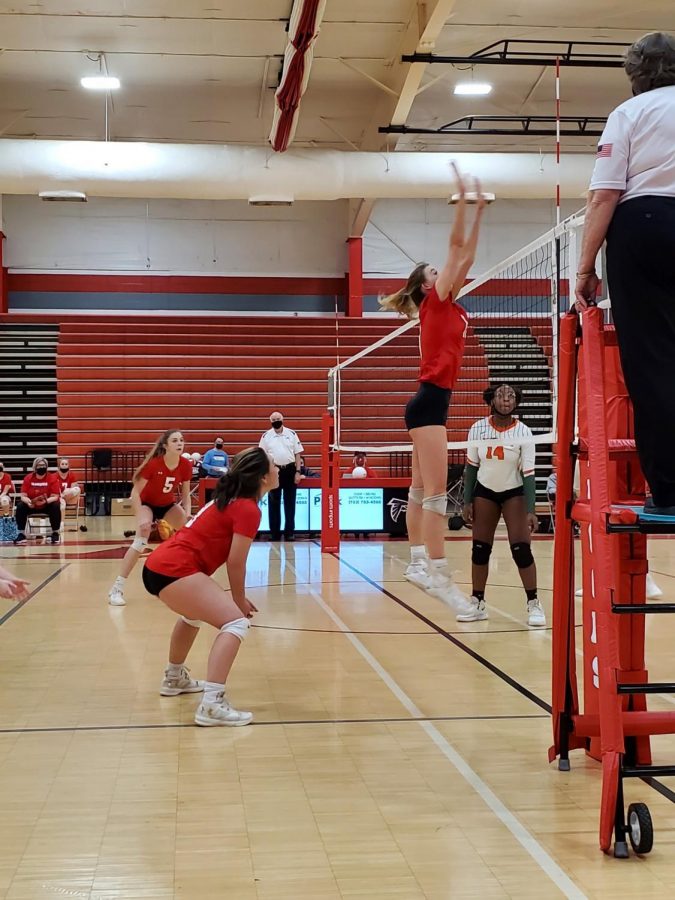 Junior Skyler Furr blocks an incoming hit during set four as her teammates cover her.
