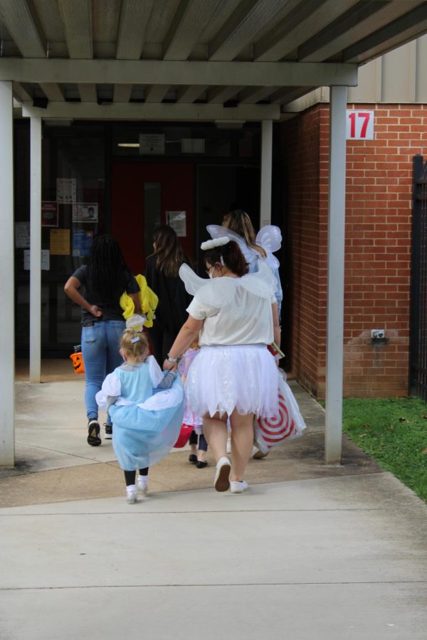 Childhood Development students take preschoolers trick-or-treating to different classes.