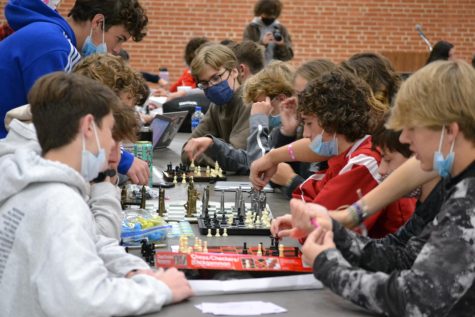 Students of all ages gather to play games of chess with one another.