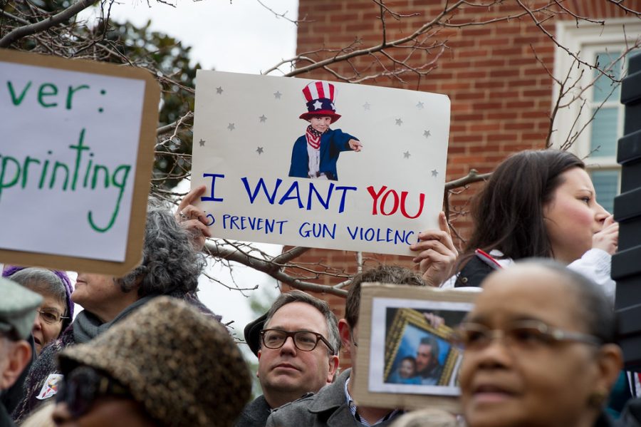 People+hold+up+signs+during+a+protest+against+gun+violence.