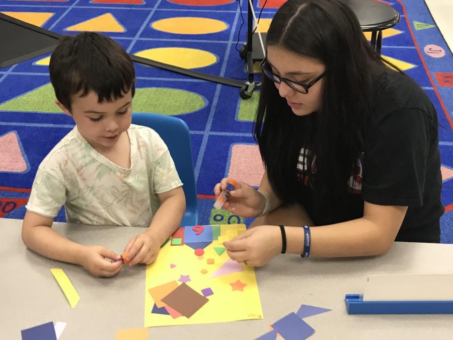 Bella Martinez helps a child during Early Childhood Education.