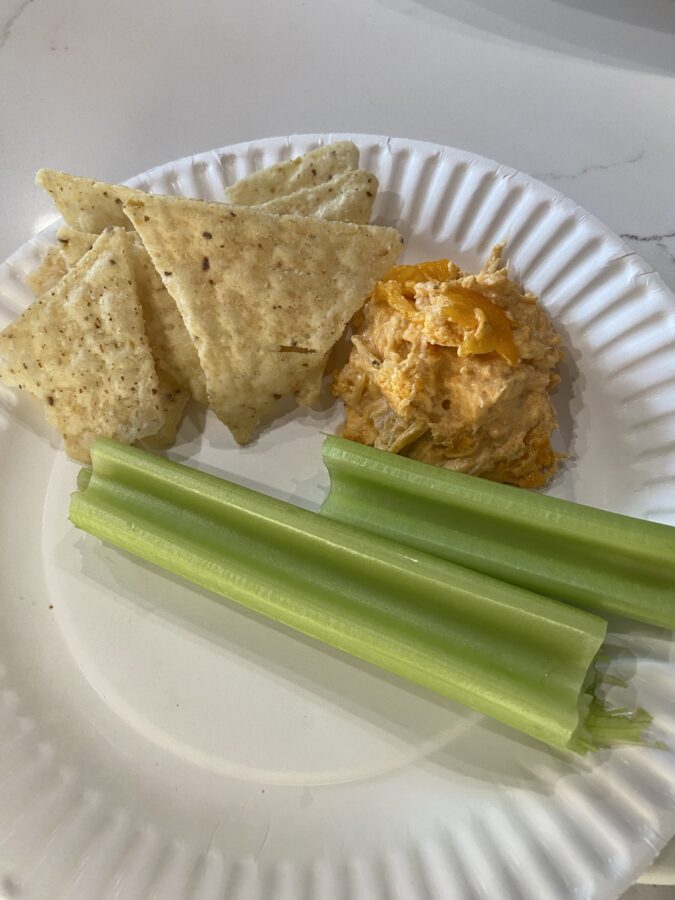 The buffalo chicken dip, being served with tortilla chips and some celery sticks.