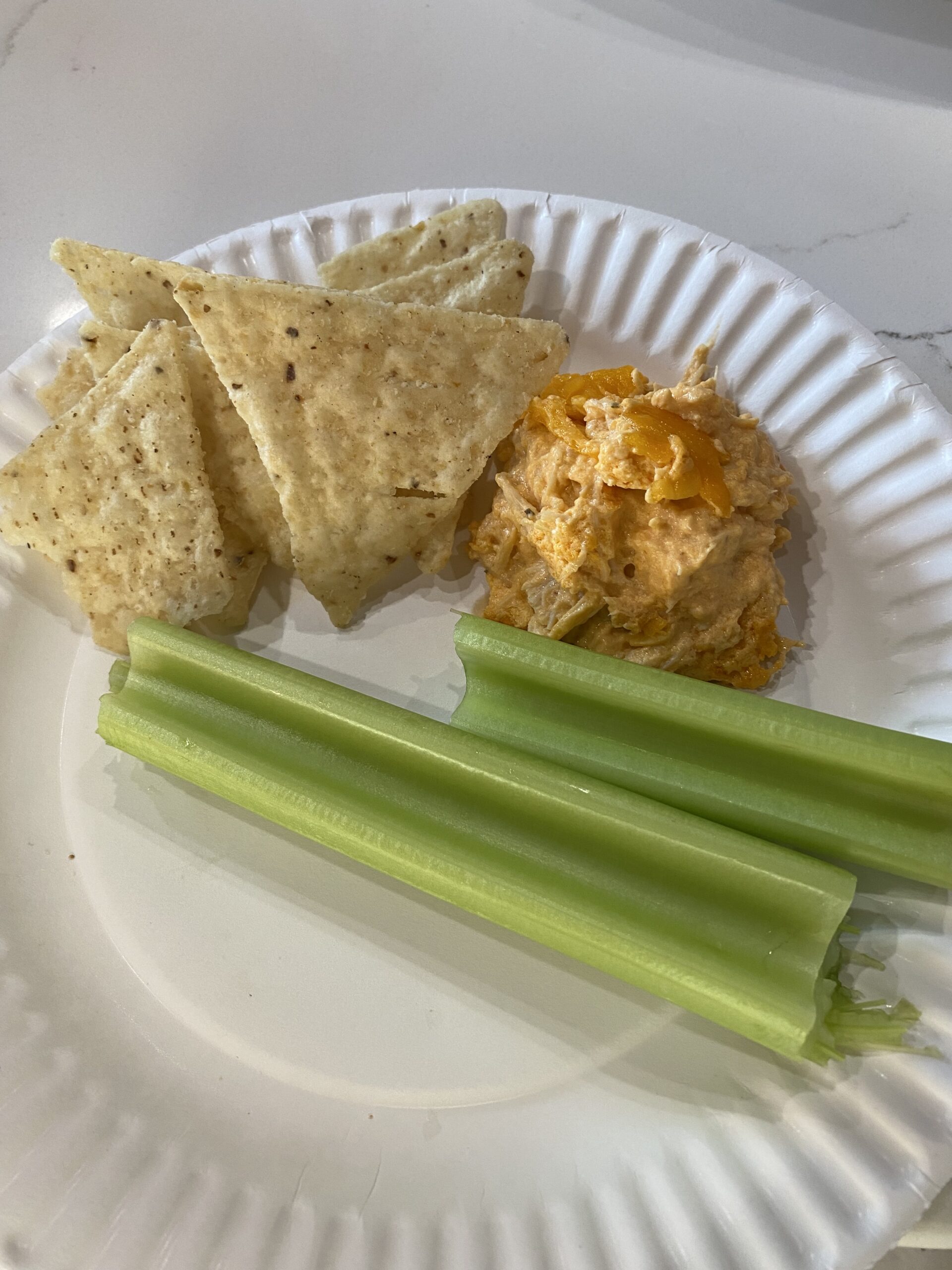The buffalo chicken dip, being served with tortilla chips and some celery sticks.