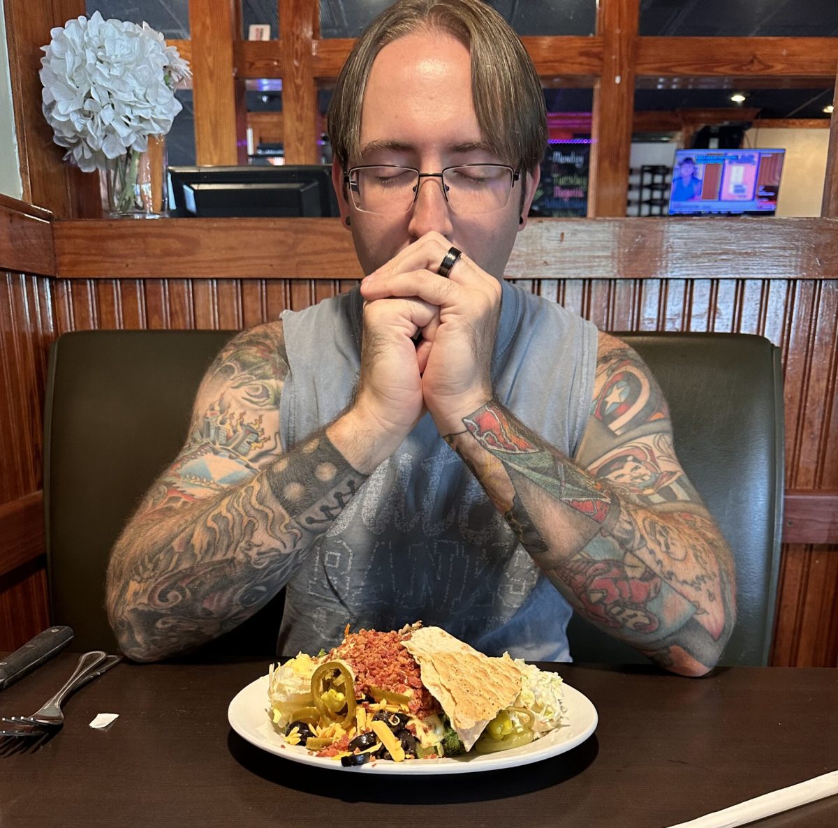 Mr. Sova flaunts his tattoos while enjoying a delectable salad
