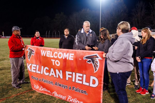 During the the renaming ceremony of Kelican Field at Fauquier High School, former assistant principal Jim Raines gifts Susan Kelican a plaque in memoriam.