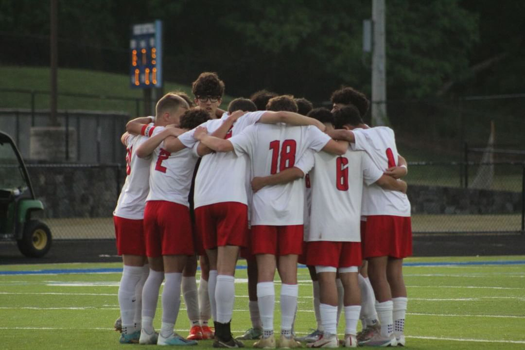 Boys soccer team huddle during a match against Tuscarora Mills High School.
