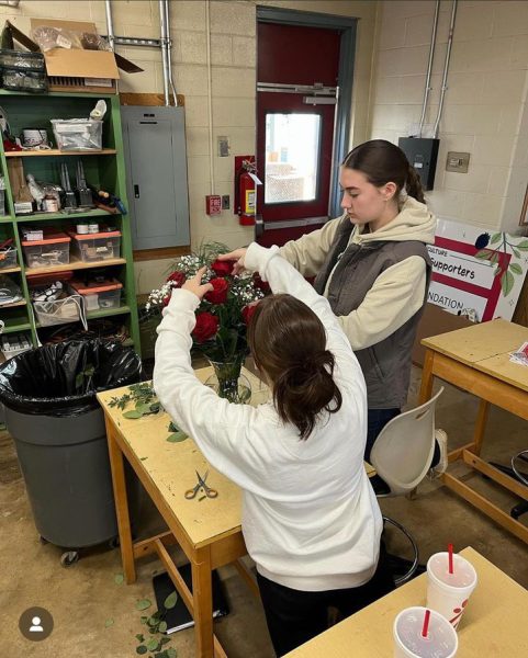 Students in Flower Design ll working on a vase arrangement.