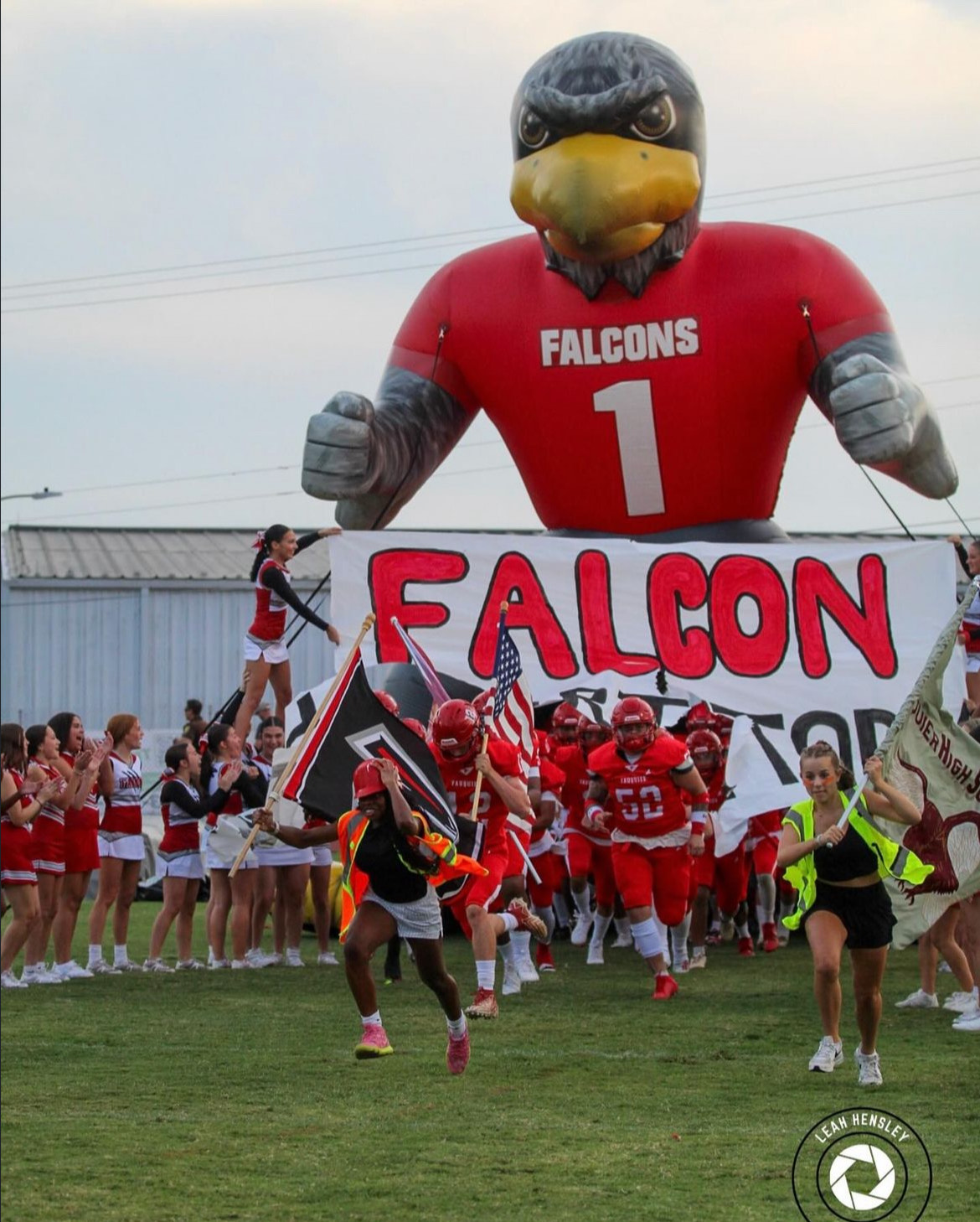 The Fauquier football team runs out on their home opener with the Zoo Captains and cheerleaders.