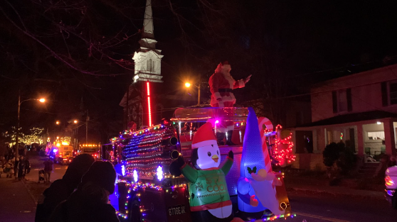 Santa Claus waves at observers while makes his way down Main Street.