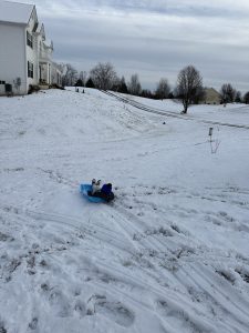 A child sledding during snowy Jan 2024. 