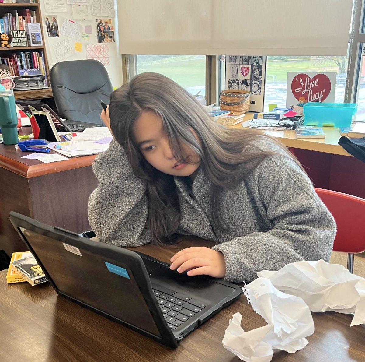 Senior Zuura Akimzhanova sits at a desk exhausted from school work.