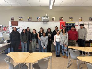 The students of the Women in History course, taught by Elizabeth Glascock, pose for a photo in the front of the classroom.