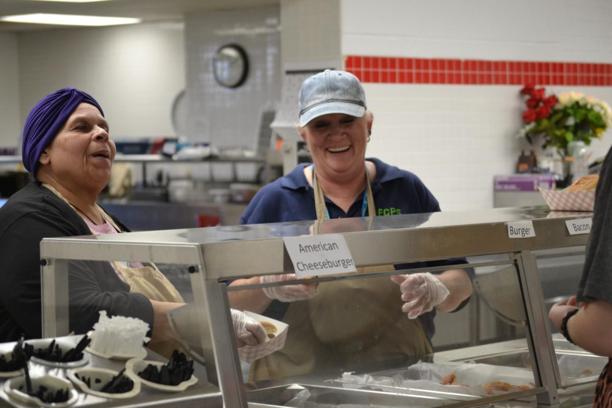 Fauquier High School lunch ladies laughing with a student.