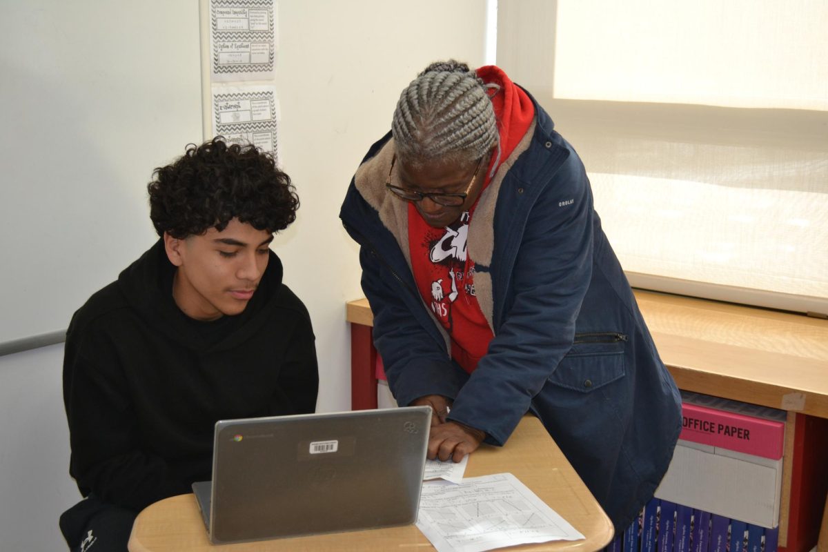 Gwendolyn Gains assisting a student with his math work. 