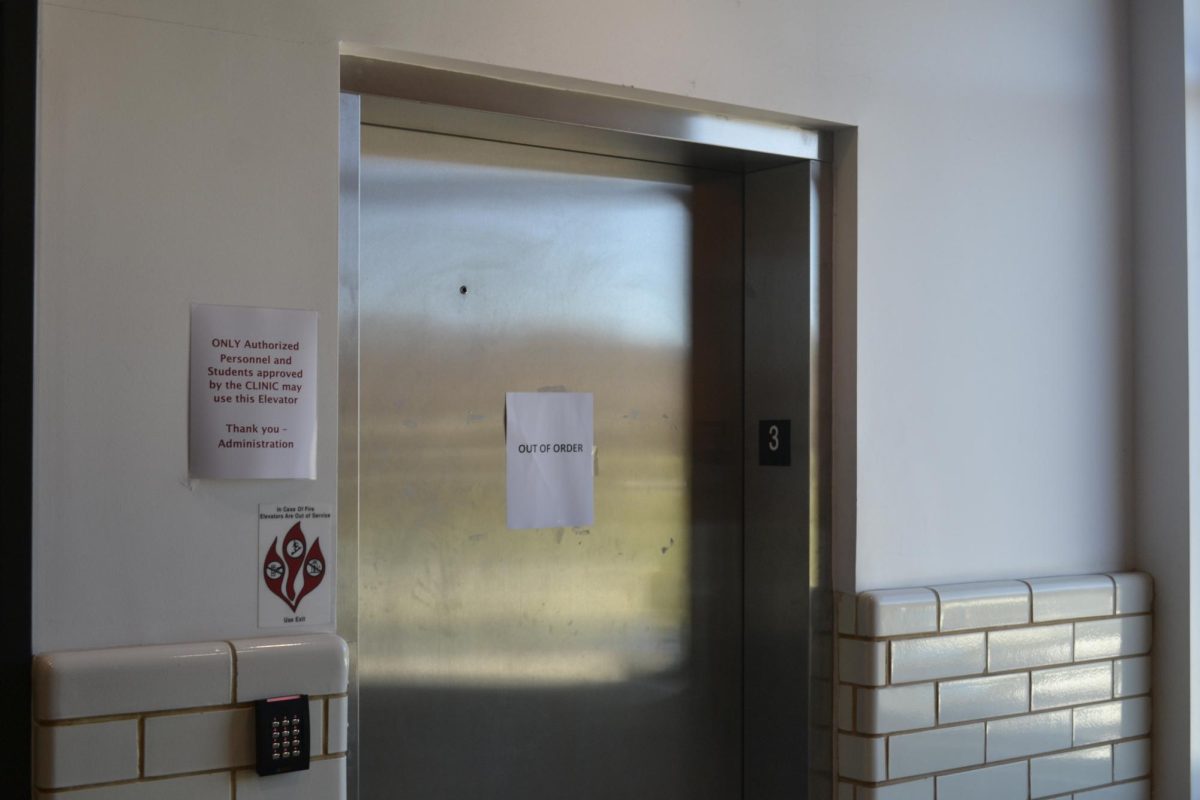 The elevator located in the main building displaying an out of order sign.
