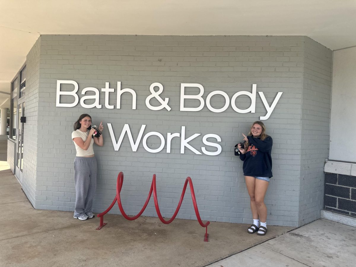 Juniors Leah Howland and Aubrey Anderson smile in front of Warrenton's new Bath and Body Works location.