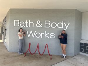 Juniors Leah Howland and Aubrey Anderson smile in front of Warrenton's new Bath and Body Works location.