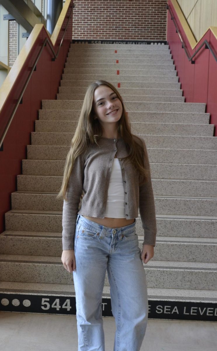 Freshman, Addison Whetzel shows off her trending and autumnal outfit featuring black Birkenstock clogs, light wash jeans, and a neutral cashmere cardigan. 