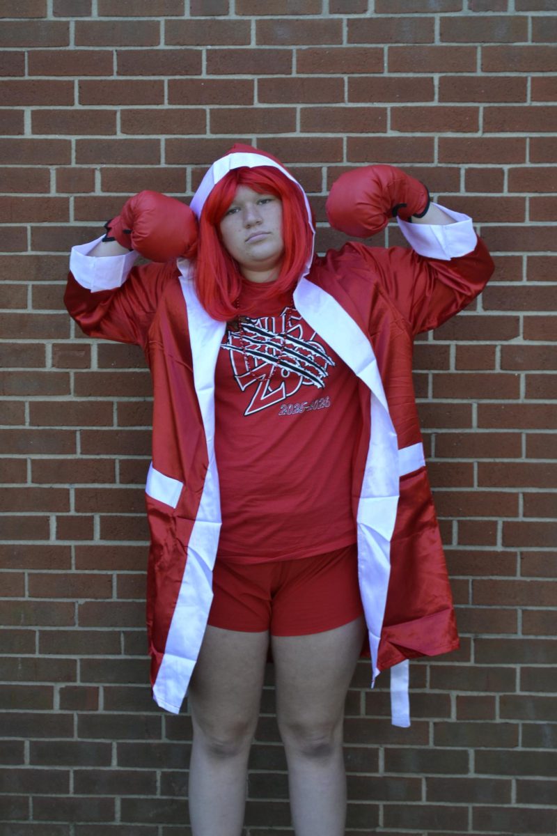 Senior Kiersten Clark flexes to show off her outfit for Homecoming spirit week, which follows the class colors theme.