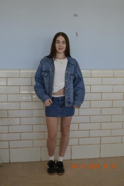 Bella Kurelich poses in a denim-on-denim jacket and skirt combo layered on a white tee.