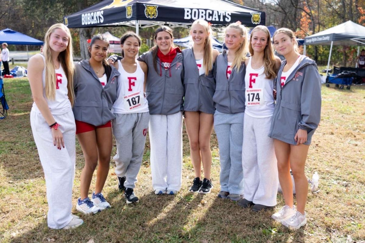 The girl's cross country team posing for a photo during the state championship.