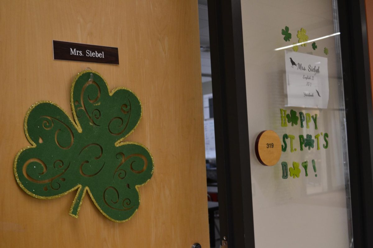 English teacher Austin Siebel decorates her door for St. Patrick's Day.