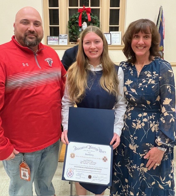 Teacher of the Year, Sandra Shipe, stands smiling with former Principal David Ferguson and senior Delaney [Grace] Faulk.