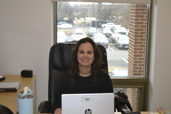 Principal Donna Guzman sits smiling in her office, working diligently.