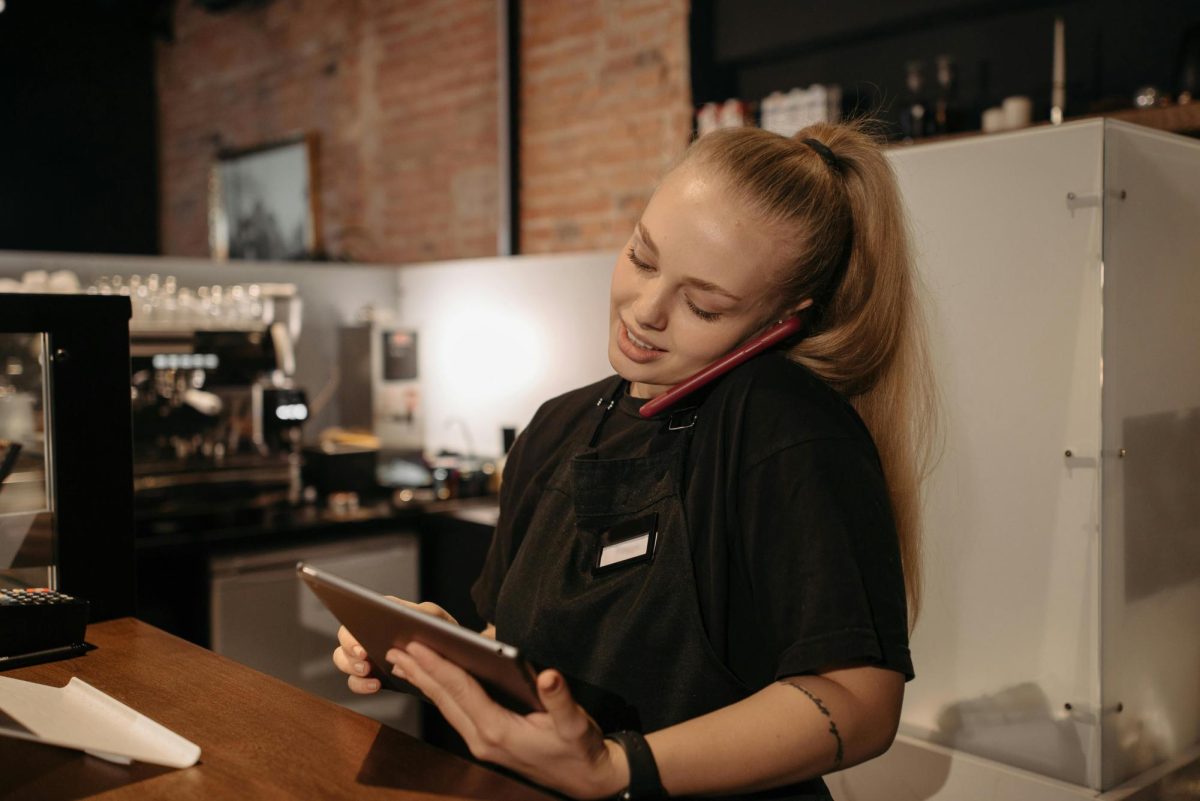 A young woman takes on working duties at a coffee shop.
