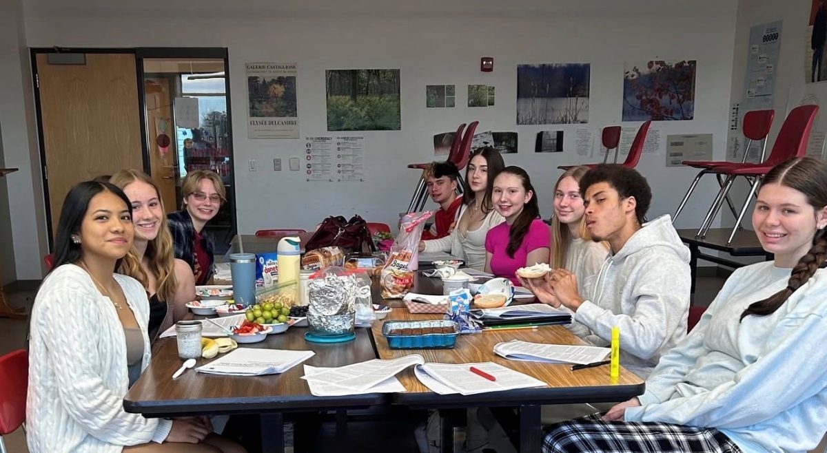 Students gather in class while balancing assignments and discussing whether AP classes truly prepare them for college.