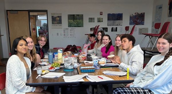 Students gather in class while balancing assignments and discussing whether AP classes truly prepare them for college.