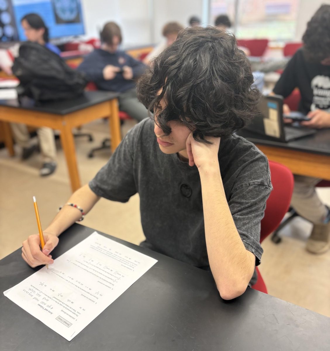 A student works on an assignment while feeling the pressure and exhaustion that many students experience during junior year.