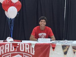 Senior Joel Williams posing at his table on signing day.