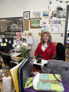 Seated with a smile, art teacher Dawn Brown reflects on a career filled with creativity.